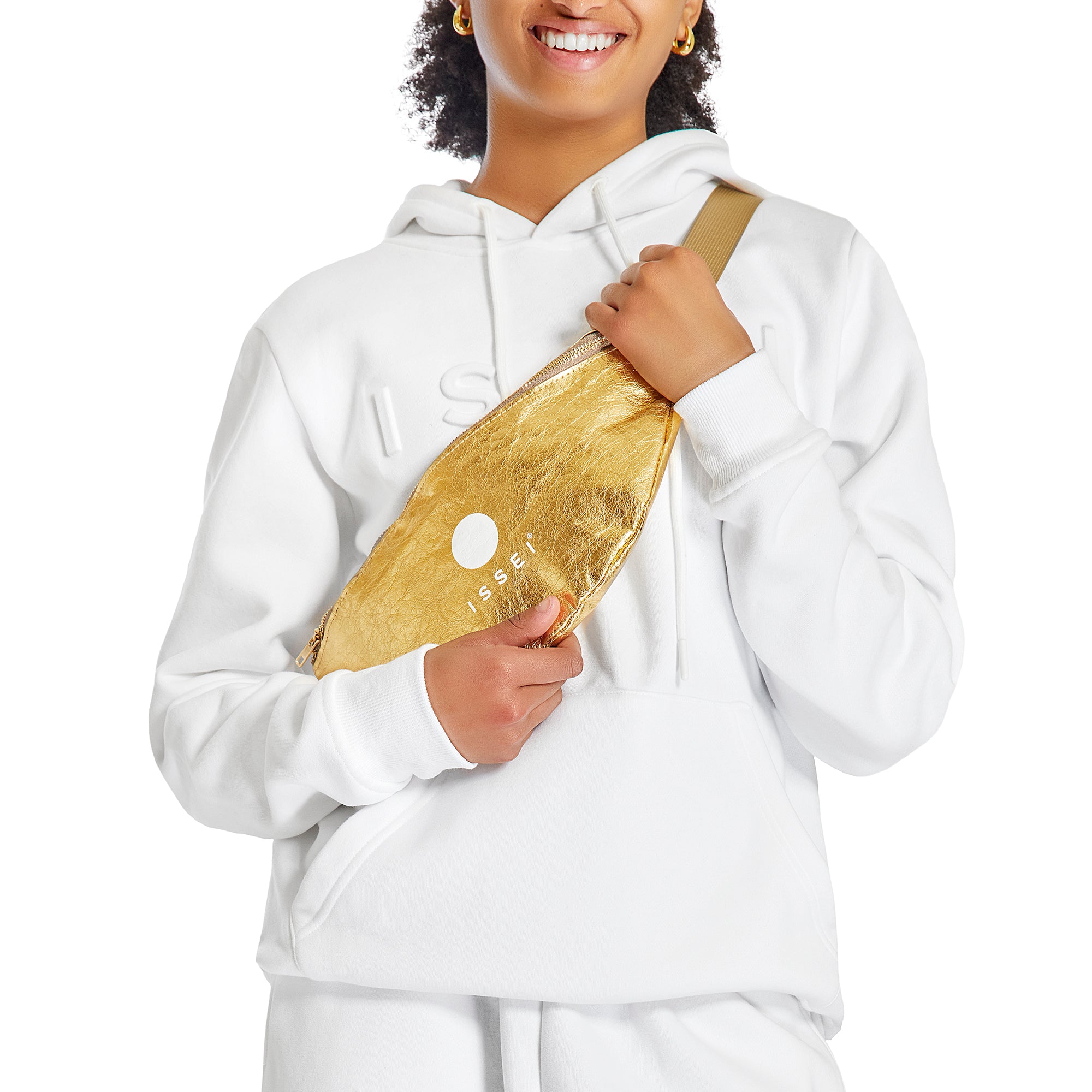 Person wearing a white Issei hoodie with a gold metallic fanny pack.