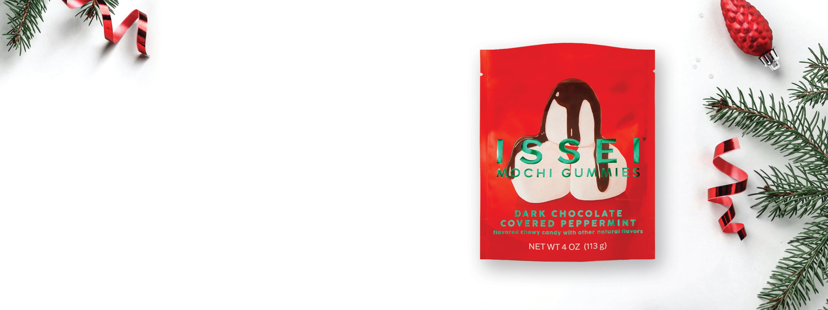 Red package of Issei Mochi Gummies Dark Chocolate Covered Peppermint on a white background with Christmas decorations.